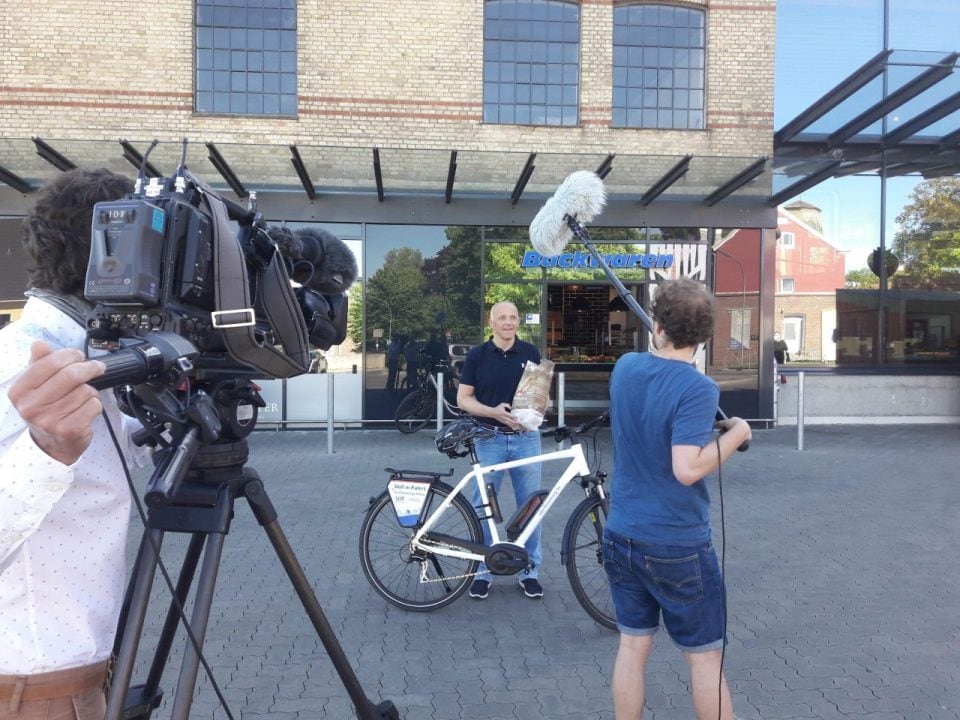 Jürgen Möller (Vorstandsvorsitzender) im Interview mit dem NDR-Fernsehteam vor einer der teilnehmenden Flensburger Bäcker-Filialen.