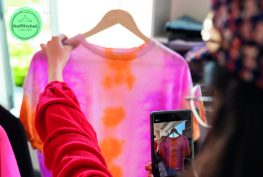 Tauschparty bei Stoffwechsel in Flensburg. Dame fotografiert in diesem Zusammenhang in einem Laden ihr ausgewähltes Kleidungsstück.